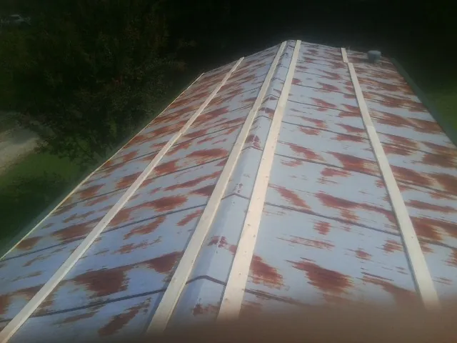 Rusted metal roof panels with new wood purlins before replacement — Storm Damage Roof Repair in East Amherst by Roofing Brothers