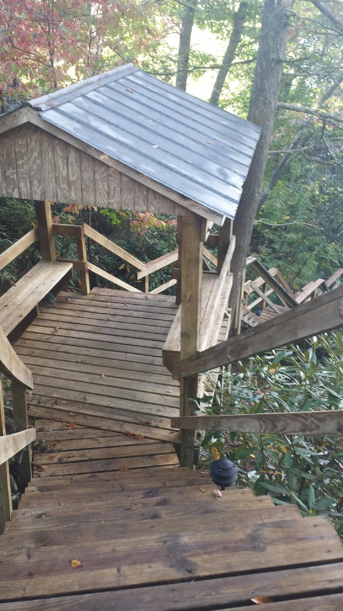 Metal roofed shelter over wooden steps on a wooded walkway — Skylight Repair & Installation work by our crew in East Amherst