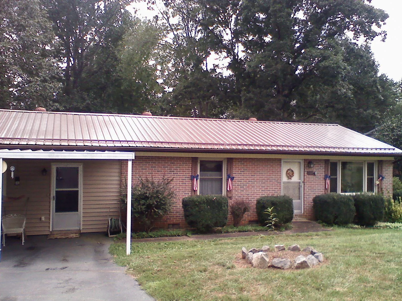 Bronze metal roof and carport on a brick ranch home — Roof Repair work by our crew in East Amherst
